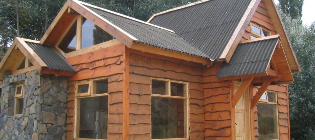 Placa bituminosa ondulada Onducober negro en techo de casa de madera